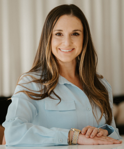 Fair skinned woman, long brunette hair, wearing baby blue blouse