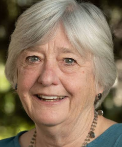 Older white woman with white short hair in a green top