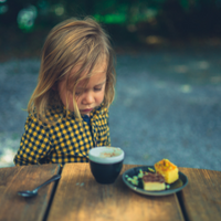 Child with long hair ignoring food