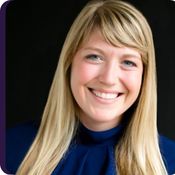 Fair skinned woman with long blonde hair in navy blue shirt on black background