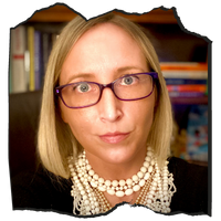 Fair skinned woman with blonde hair with glasses and wearing a pearl necklace