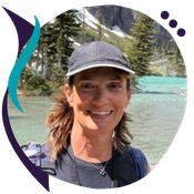 Headshot of Anne Tellez, a woman wearing a gray baseball cap and backpack, smiling outdoors near a turquoise mountain lake, shown in a circular crop with a teal and purple decorative swoosh graphic element