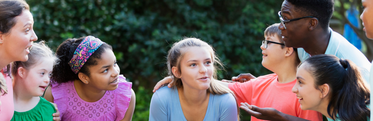 group of children ages 8-14 listening to adults