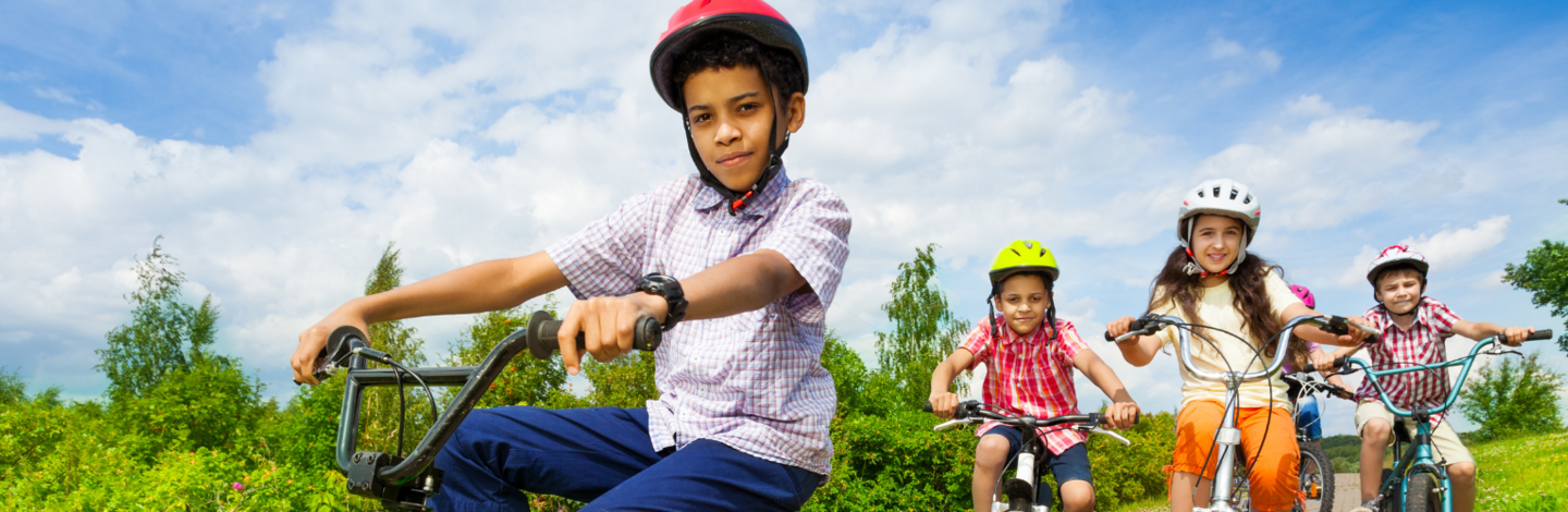 Sunny, blue skies, 4 children riding bikes