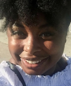 Black woman smiling with hair pulled back