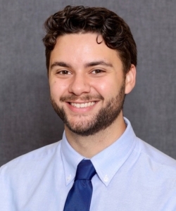 Fair skin, short brunette hair, male, in blue button up and blue tie